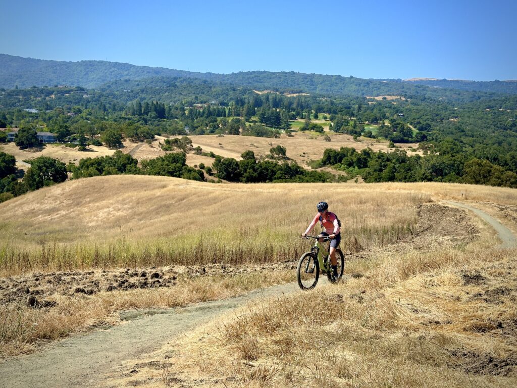 senior mountain biking up a gentle slope